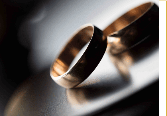 A close up of two wedding rings on top of a table.