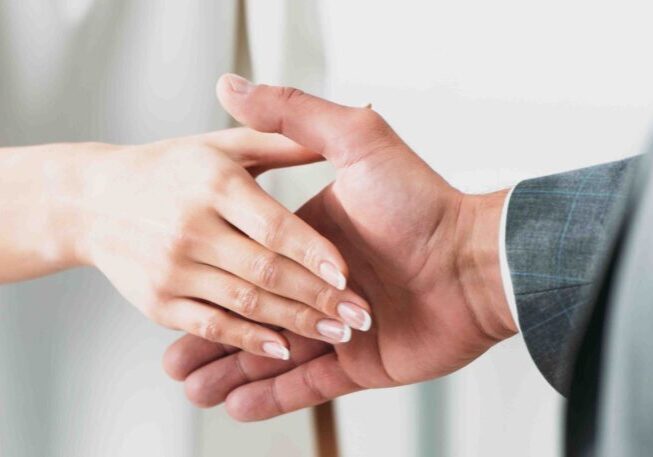 A man and woman holding hands in front of each other.